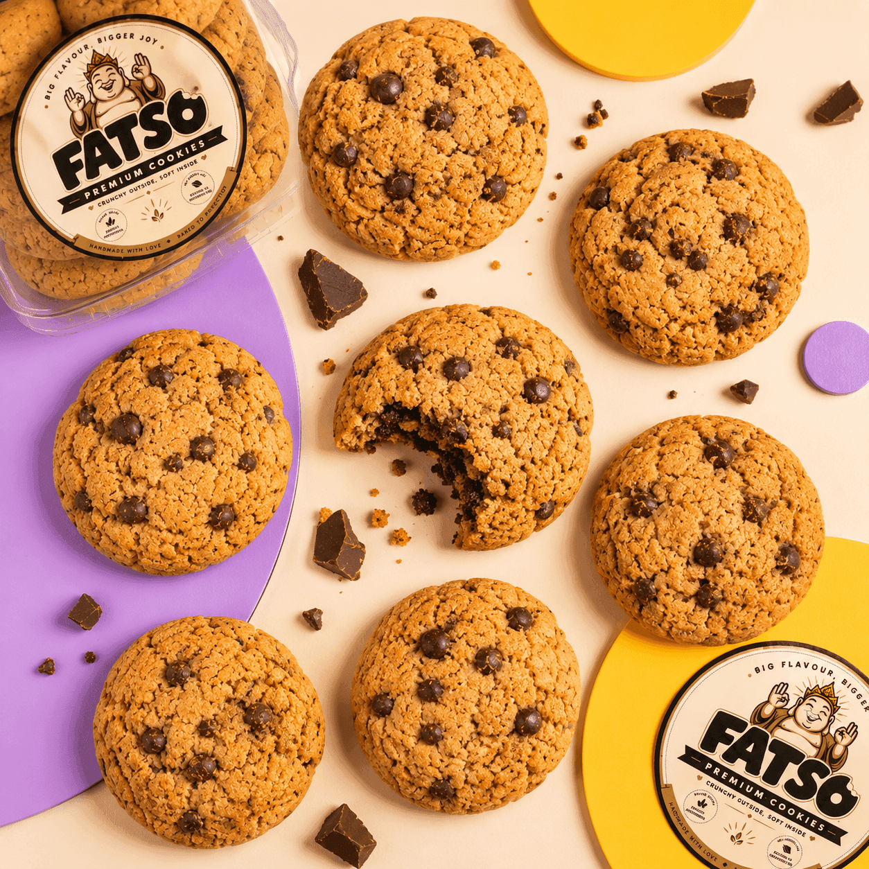 Fatso cookie tub surrounded by chunky chocolate cookies on a pastel set