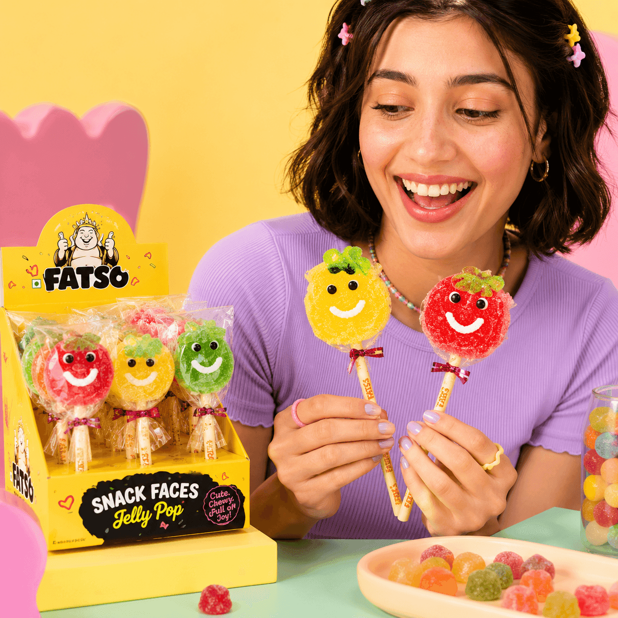 Woman holding bright Fatso smiley jelly sweets in a playful scene